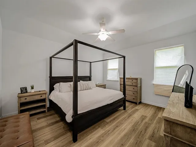 a bedroom with a bed and a flat tv screen on dresser
