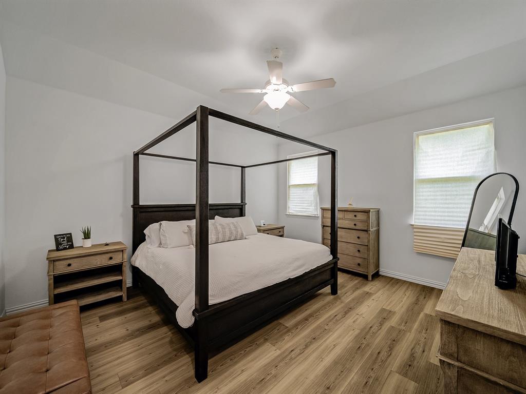 2104 Franklin Road Princeton, TX 75407 - Photo 15 of 36 a bedroom with a bed and a flat tv screen on dresser