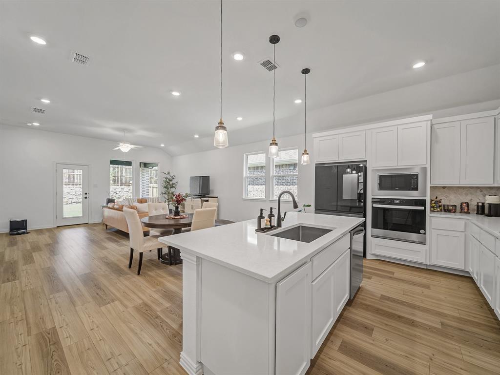 2104 Franklin Road Princeton, TX 75407 - Photo 4 of 36 a large kitchen with kitchen island a sink table and chairs