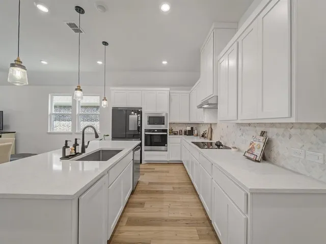 a kitchen with counter top space a sink stainless steel appliances and cabinets