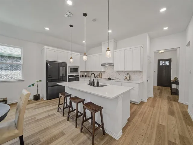 a large kitchen with a table and chairs in it