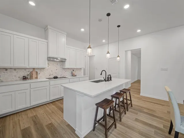 a kitchen with a table chairs sink and cabinets
