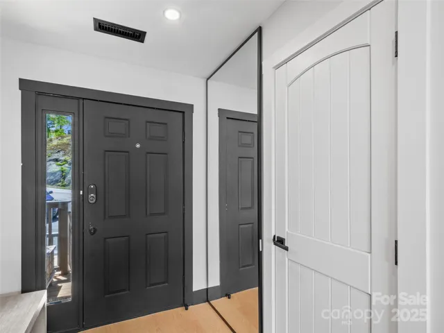 a view of a hallway with wooden floor and closet