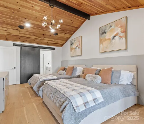 a bedroom with a large bed and a chandelier