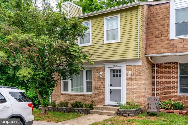 a view of a house with a yard and large tree