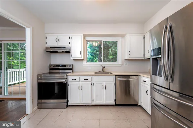 a kitchen with stainless steel appliances a stove sink and refrigerator