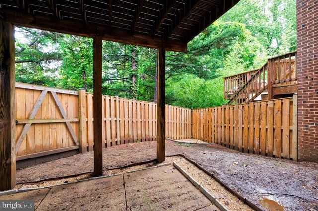 a view of a backyard with wooden fence and floor