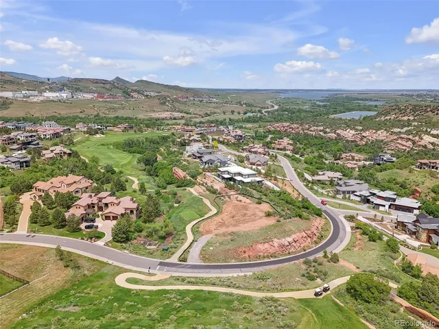 an aerial view of residential houses with outdoor space and trees