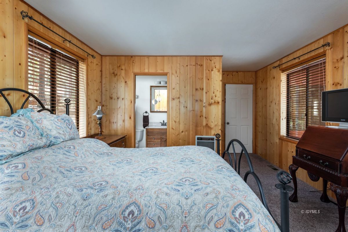 27140 Saunders Meadow Road Idyllwild, CA 92549 - Photo 14 of 25 a bedroom with a bed a table and chair