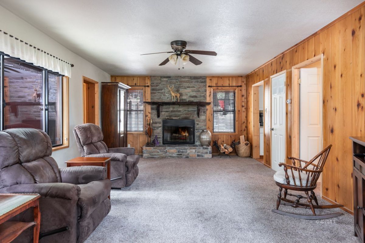 27140 Saunders Meadow Road Idyllwild, CA 92549 - Photo 4 of 25 a living room with furniture a fireplace and a ceiling fan