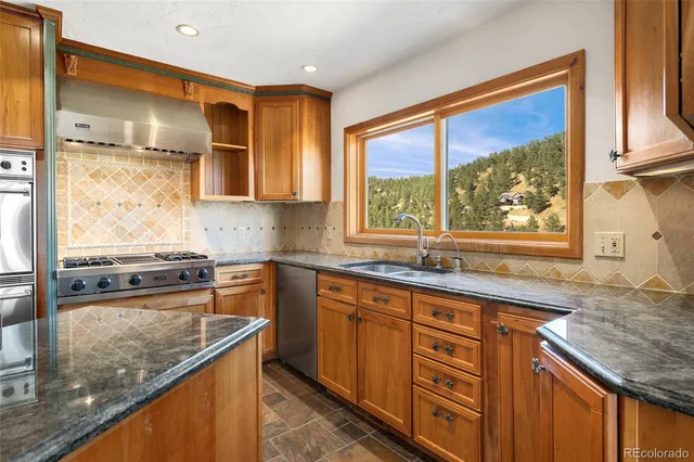 a kitchen with stainless steel appliances granite countertop a sink stove and cabinets