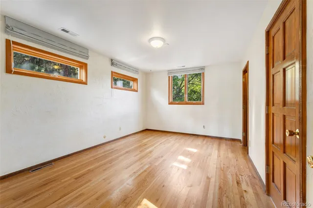 a view of a livingroom with wooden floor and a large window
