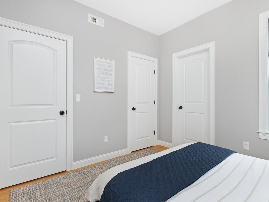 286 Summer Street, Unit 2 Somerville, MA 02144 - Photo 23 of 37 a bedroom with a bed and wooden floor