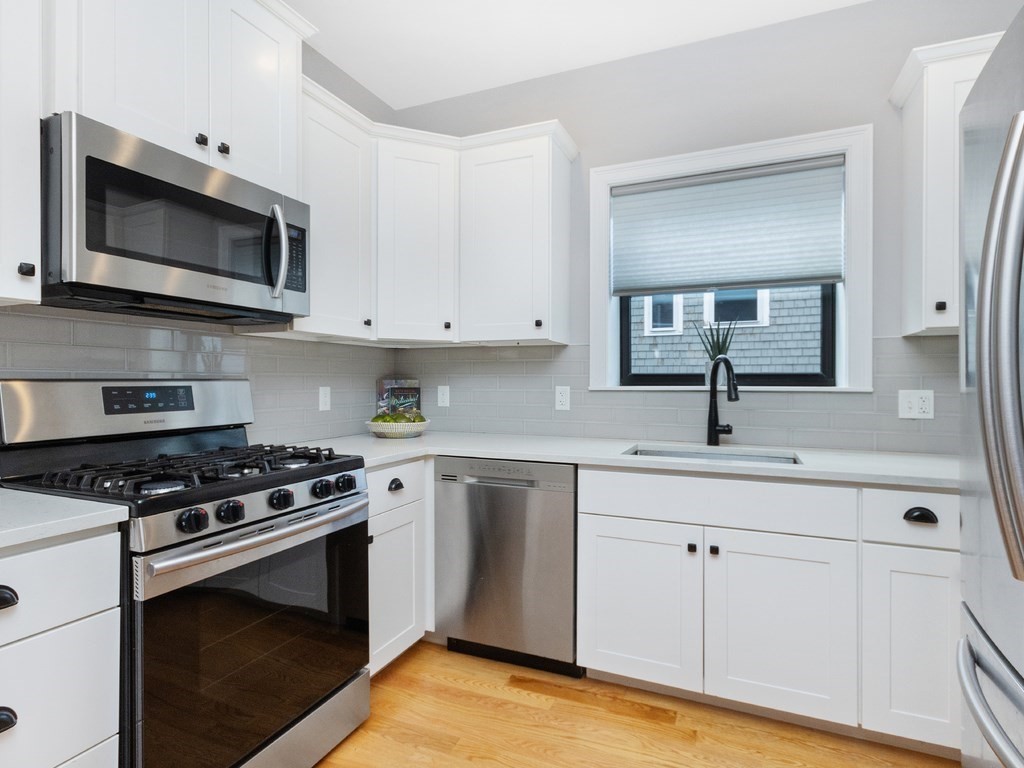 286 Summer Street, Unit 2 Somerville, MA 02144 - Photo 9 of 37 a kitchen with white cabinets and appliances