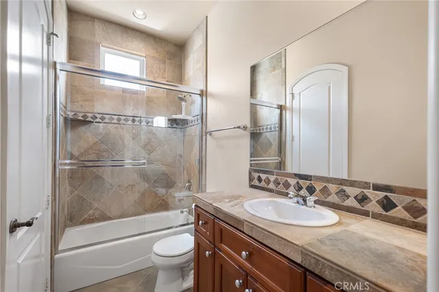 a bathroom with a granite countertop sink a mirror and a shower