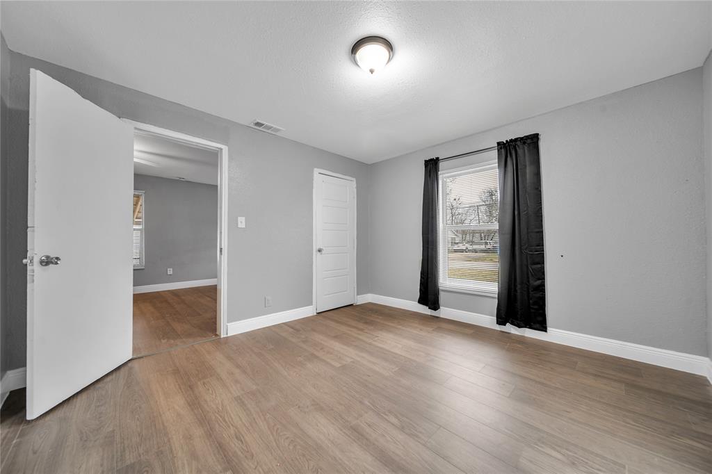 802 South Jackson Street Kaufman, TX 75142 - Photo 11 of 16 an empty room with wooden floor and windows