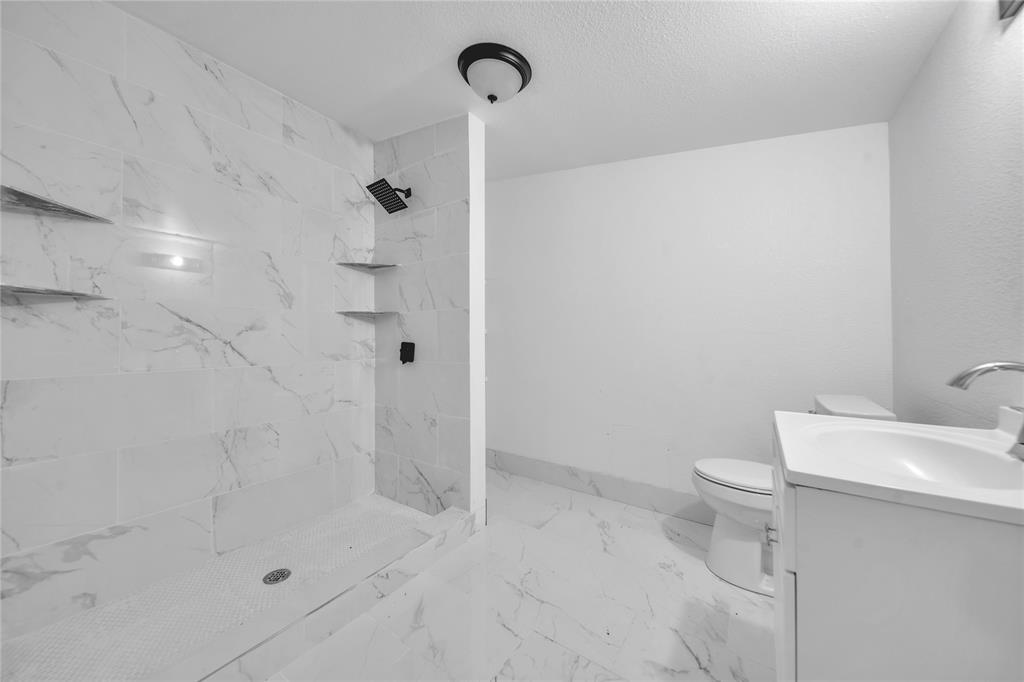 802 South Jackson Street Kaufman, TX 75142 - Photo 13 of 16 a bathroom with a shower a toilet and sink