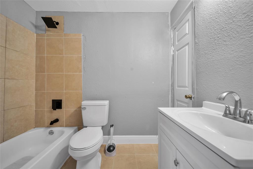 802 South Jackson Street Kaufman, TX 75142 - Photo 14 of 16 a bathroom with a sink a toilet and shower