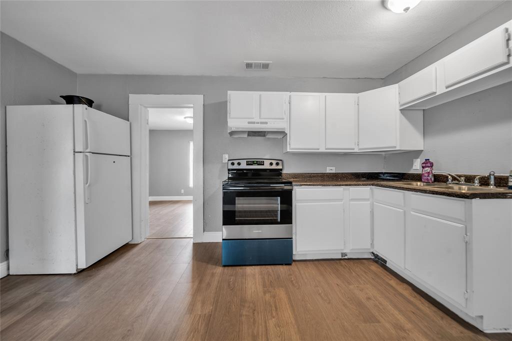 802 South Jackson Street Kaufman, TX 75142 - Photo 7 of 16 a kitchen with granite countertop a refrigerator and a stove top oven