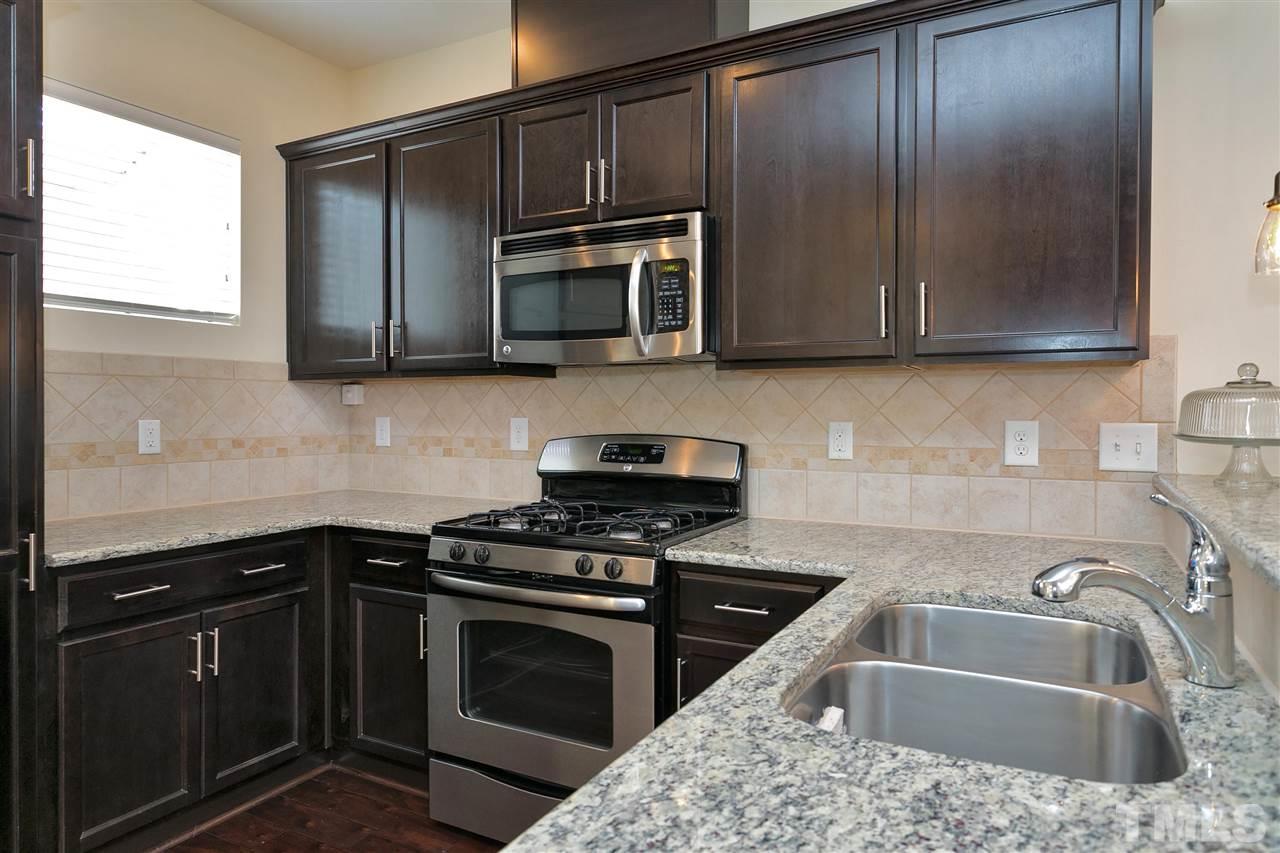 1412 Crafton Way Raleigh, NC 27607 - Photo 12 of 25 a kitchen with granite countertop a sink stove and microwave