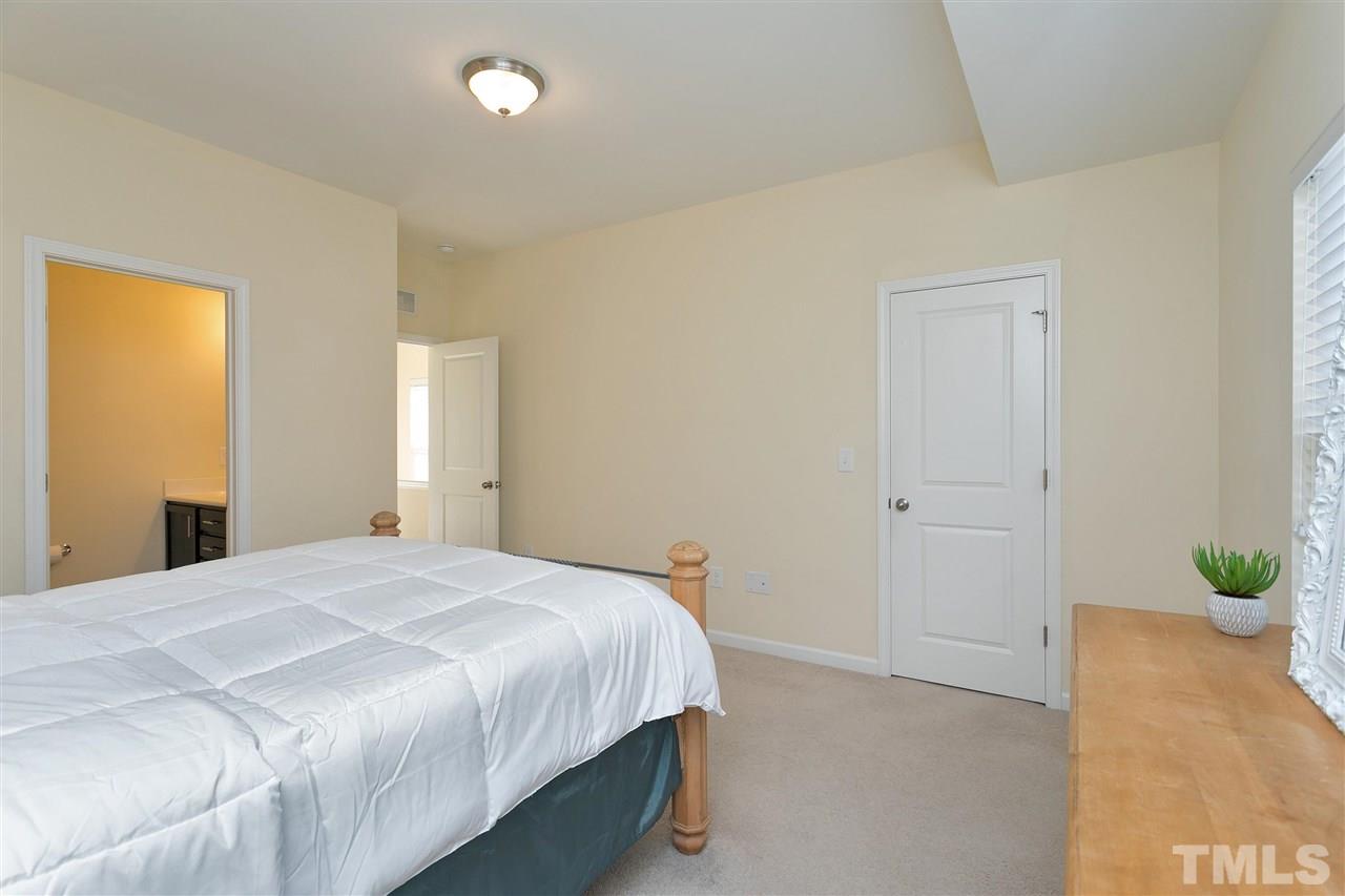 1412 Crafton Way Raleigh, NC 27607 - Photo 14 of 25 a bedroom with a bed and a potted plant