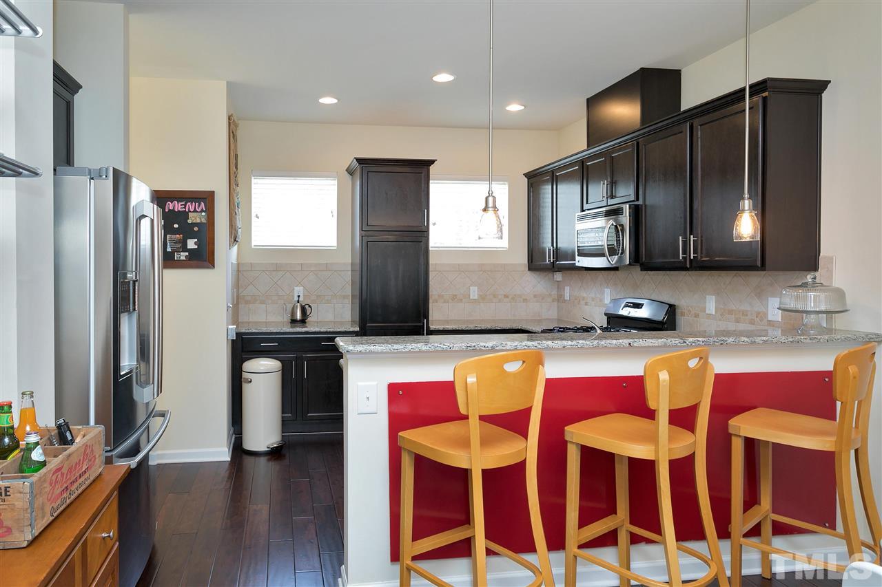 1412 Crafton Way Raleigh, NC 27607 - Photo 9 of 25 a kitchen with stainless steel appliances granite countertop a sink and a refrigerator