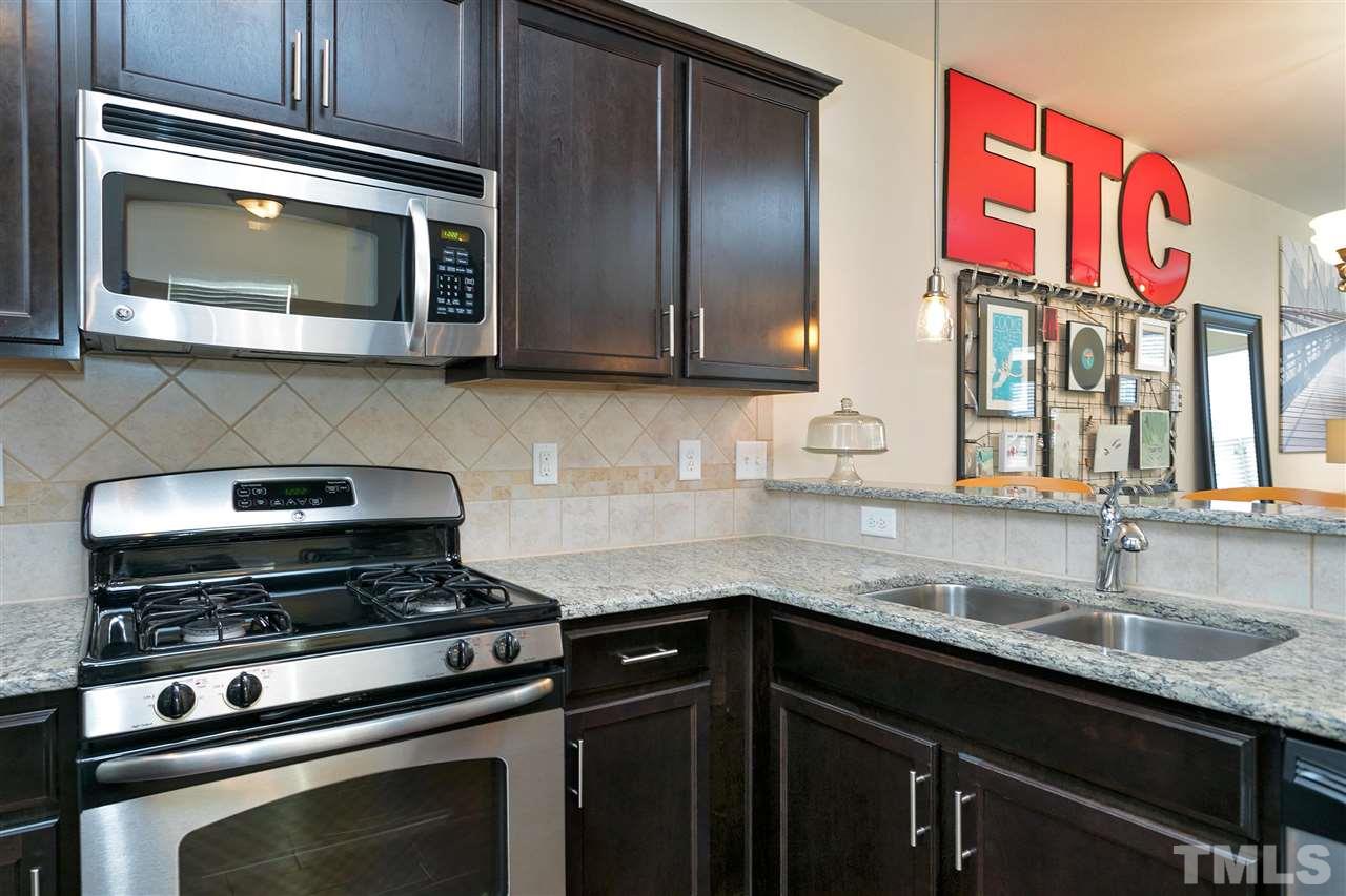 1412 Crafton Way Raleigh, NC 27607 - Photo 10 of 25 a kitchen with stainless steel appliances granite countertop a sink stove and microwave