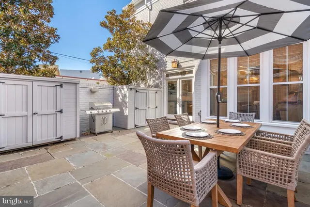 a table and chairs in front of a white house