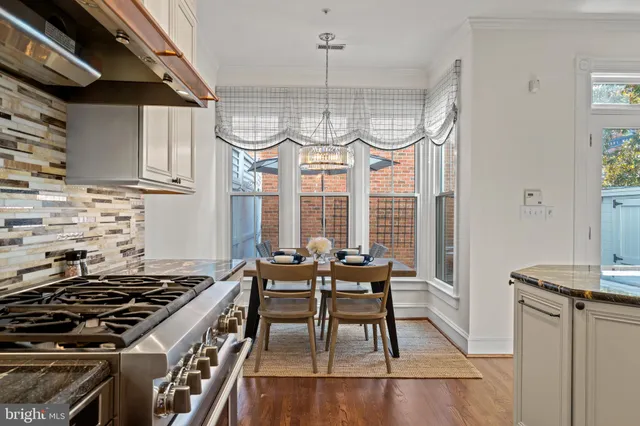 a kitchen with a stove a refrigerator and a dining table