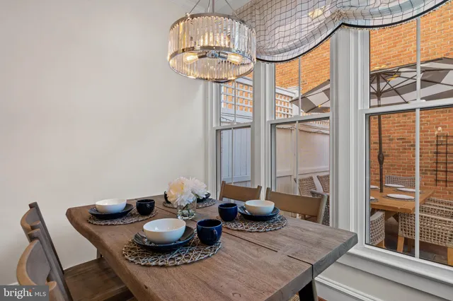 a dining room with furniture a chandelier and wooden floor