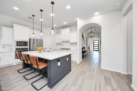 a kitchen with stainless steel appliances kitchen island a sink a stove and a window