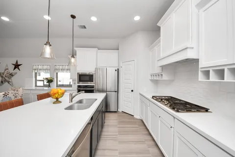 a kitchen with a sink a counter top space and stainless steel appliances