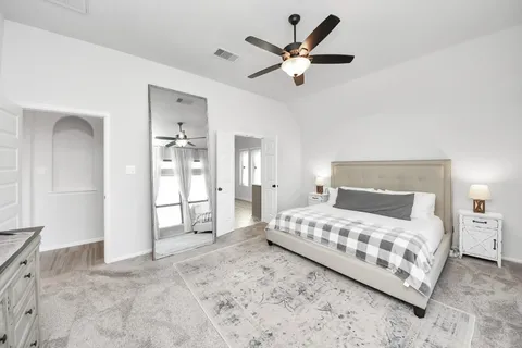 a bedroom with a large bed and a chandelier