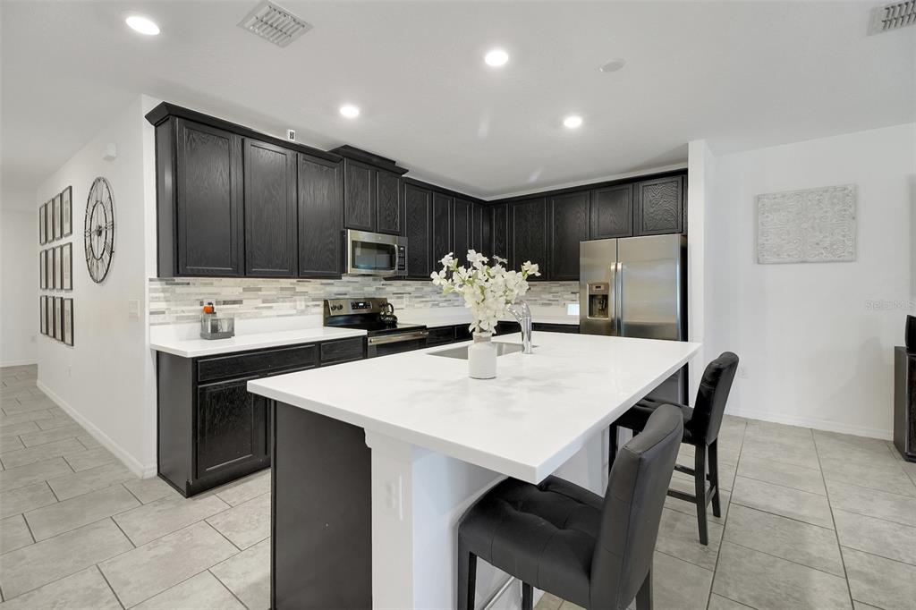 10121 Grande Loop Clermont, FL 34711 - Photo 13 of 30 a kitchen with a dining table chairs and refrigerator