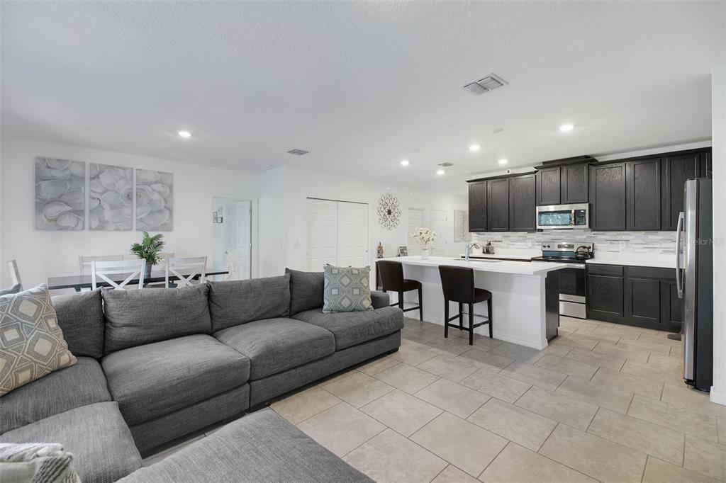 10121 Grande Loop Clermont, FL 34711 - Photo 15 of 30 a living room with stainless steel appliances kitchen island granite countertop a couch and a view of living room
