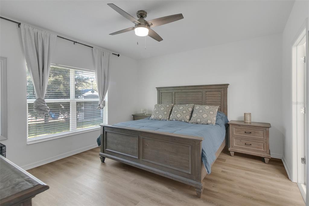 10121 Grande Loop Clermont, FL 34711 - Photo 23 of 30 a bedroom with a bed chandelier and a window