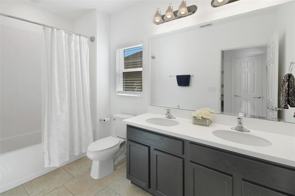 10121 Grande Loop Clermont, FL 34711 - Photo 26 of 30 a bathroom with a double vanity sink toilet and a mirror