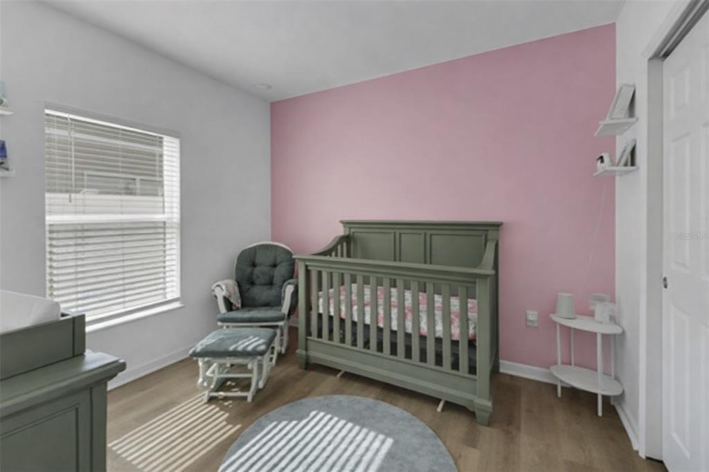 10121 Grande Loop Clermont, FL 34711 - Photo 27 of 30 a bedroom with a chair and wooden floor