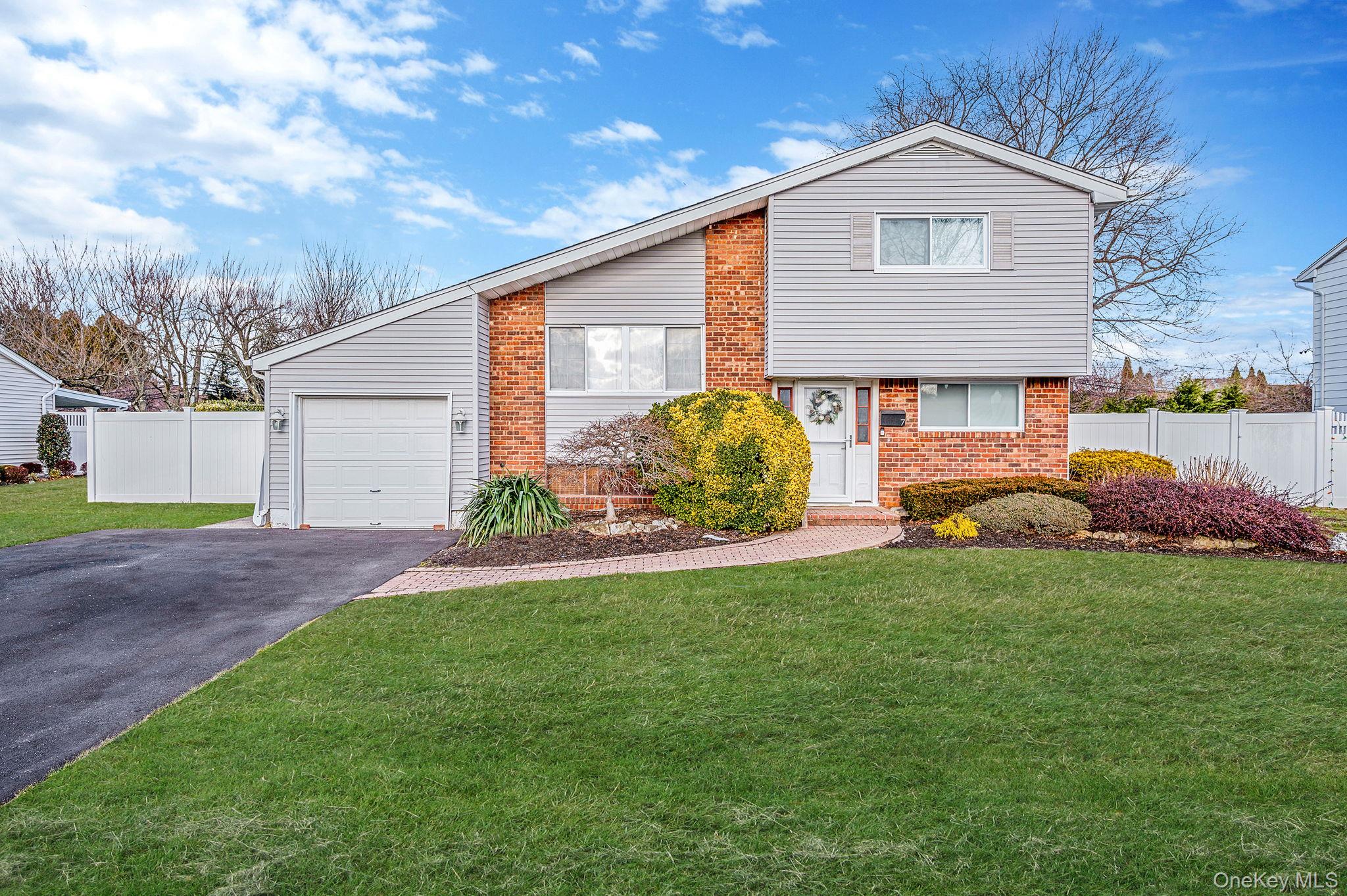 View of front of house featuring driveway and brick siding