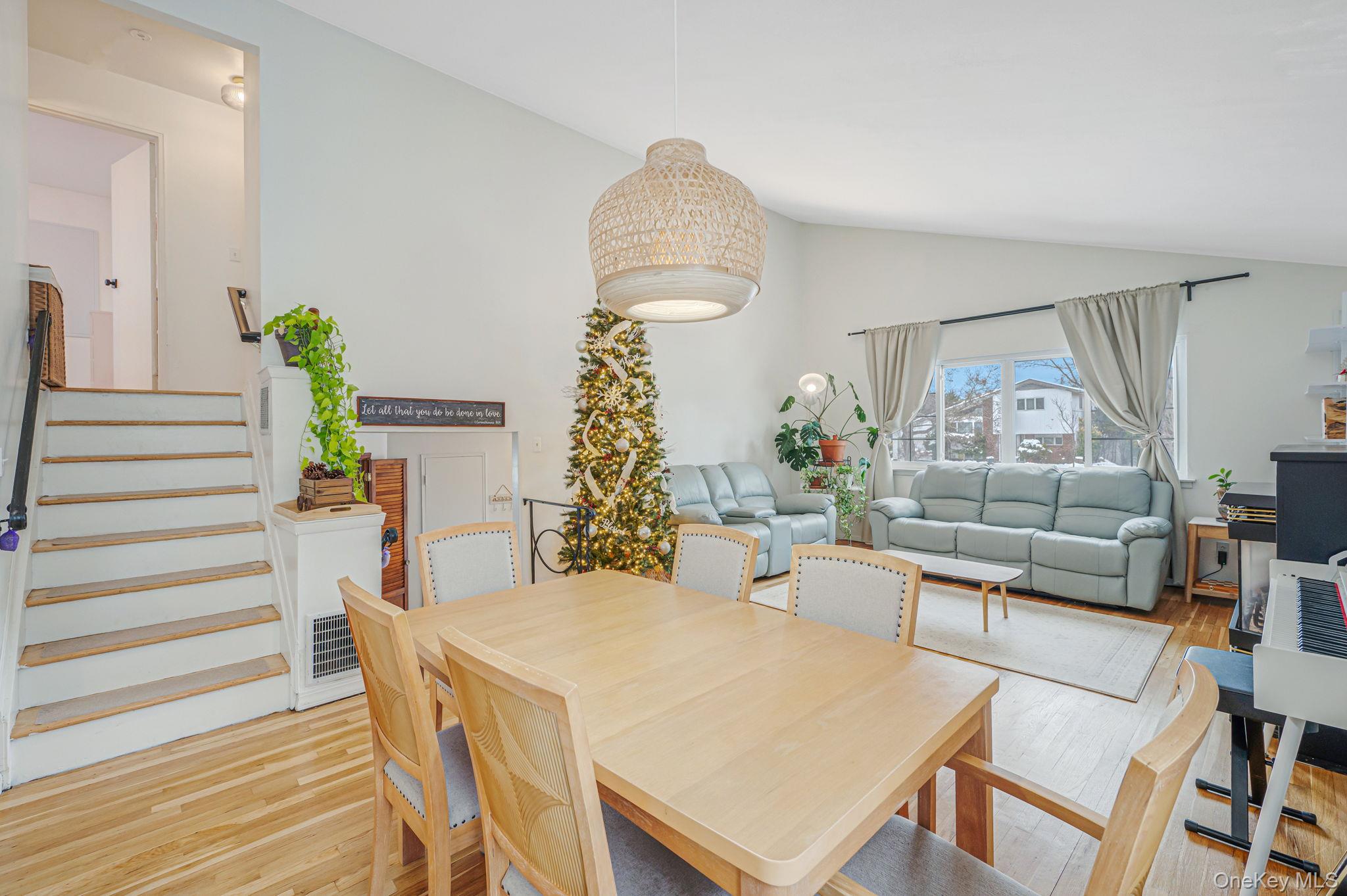 7 Seneca Drive Commack, NY 11725 - Photo 15 of 40 Dining room/open living room featuring light wood-style floors, stairway, and high vaulted ceiling