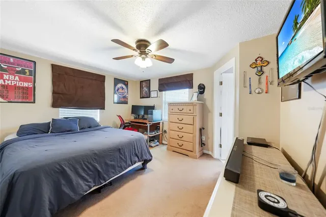a bedroom with a bed and a flat tv screen on dresser