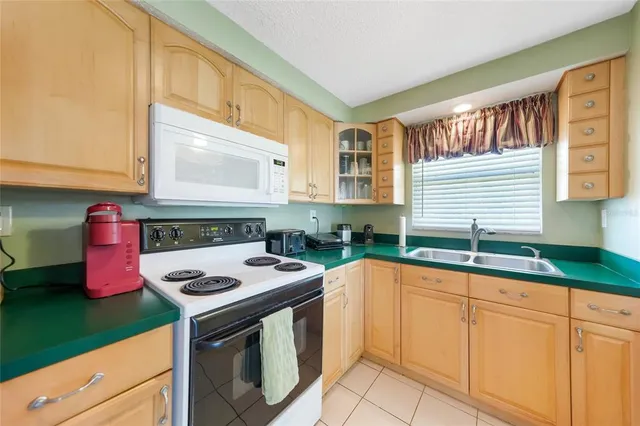 a kitchen with granite countertop a sink stove and cabinets