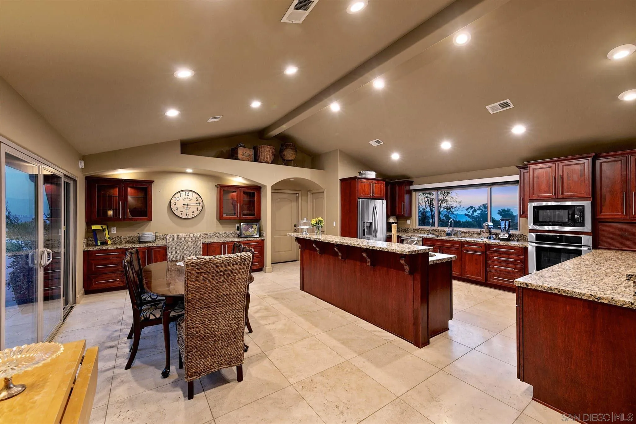 3480 Hidden Trail Drive Jamul, CA 91935 - Photo 10 of 38 a kitchen with stainless steel appliances kitchen island granite countertop a table chairs sink and cabinets