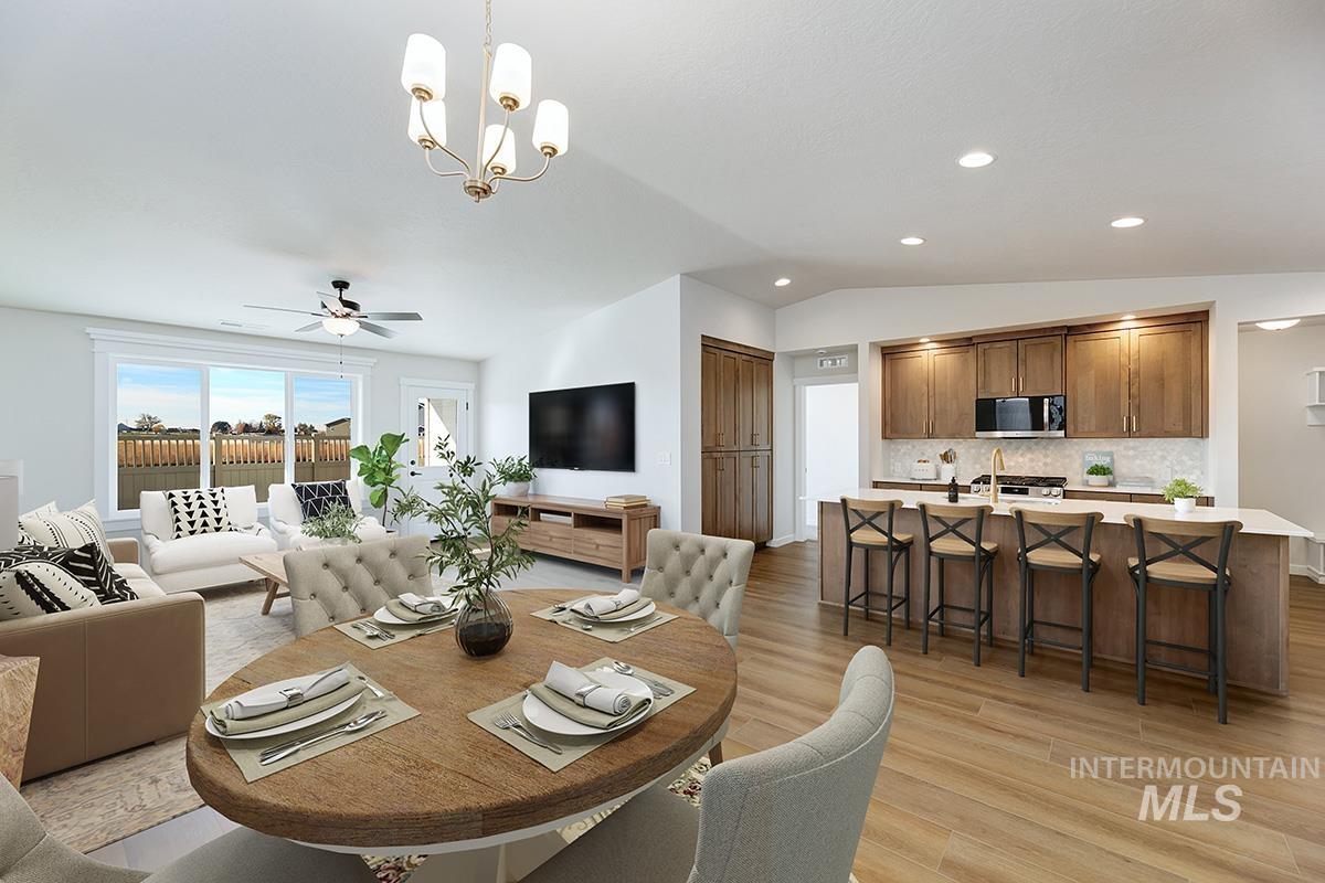 1700 East Hadler Street Meridian, ID 83642 - Photo 7 of 25 Dining space with suspended lighting, a ceiling fan, light wood finished floors, and lofted ceiling