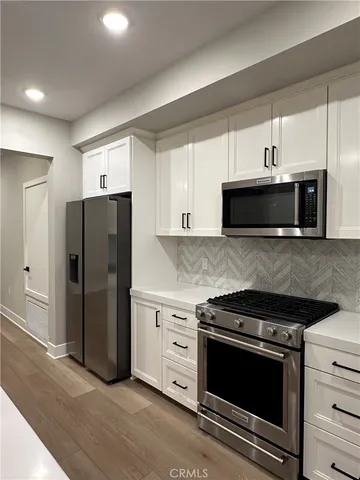 a kitchen with granite countertop a stove and a microwave