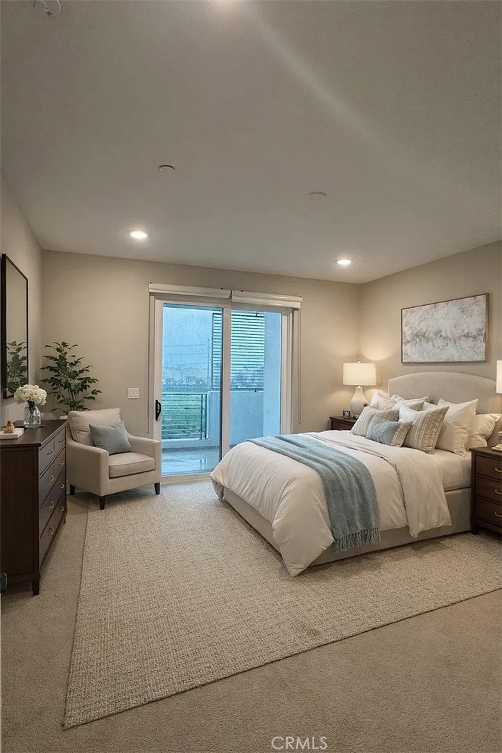 16450 Veterans Way, Unit 308 Tustin, CA 92782 - Photo 6 of 11 a spacious bedroom with a bed and glass window