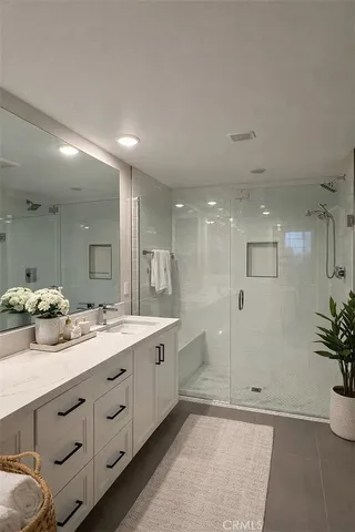 a bathroom with a double vanity sink mirror and shower