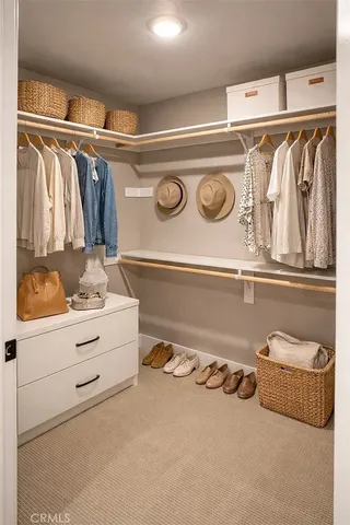a view of walk in closet with clothes and shoes