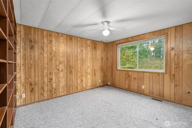 an empty room with a window and a ceiling fan