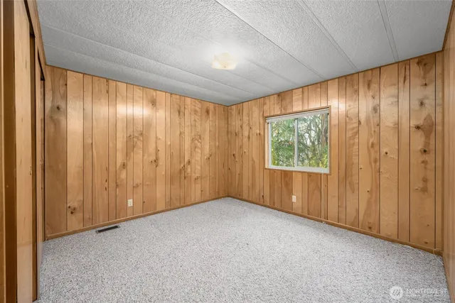 a view of an empty room with a window and a curtain
